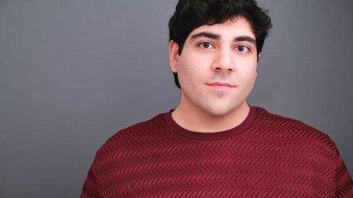 A portrait of Christopher Talia ’24 smiling and wearing a red shirt.